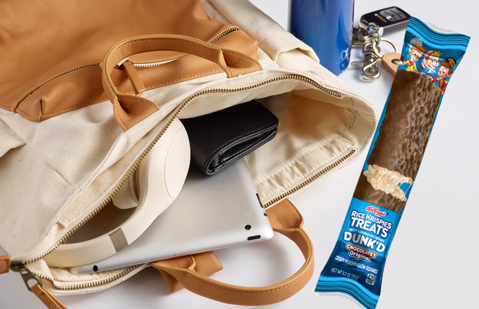 A mega size Rice Krispies Treats® pulled out from a navy blue messenger bag