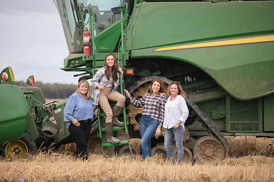 Four women standing in a farming field